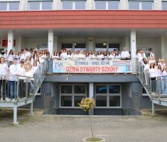 Powiększ zdjęcie Zintegrowani%20nauczyciele,%20uczniowie%20i%20inni%20pracownicy%20przed%20budynkiem%20szkoły